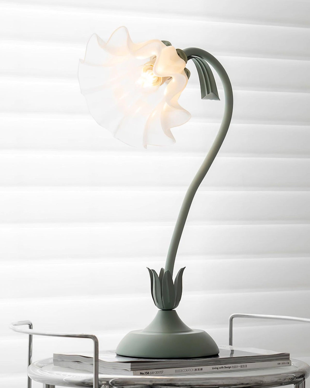 Lit flower table lamp on a marble side table against a white slatted wall