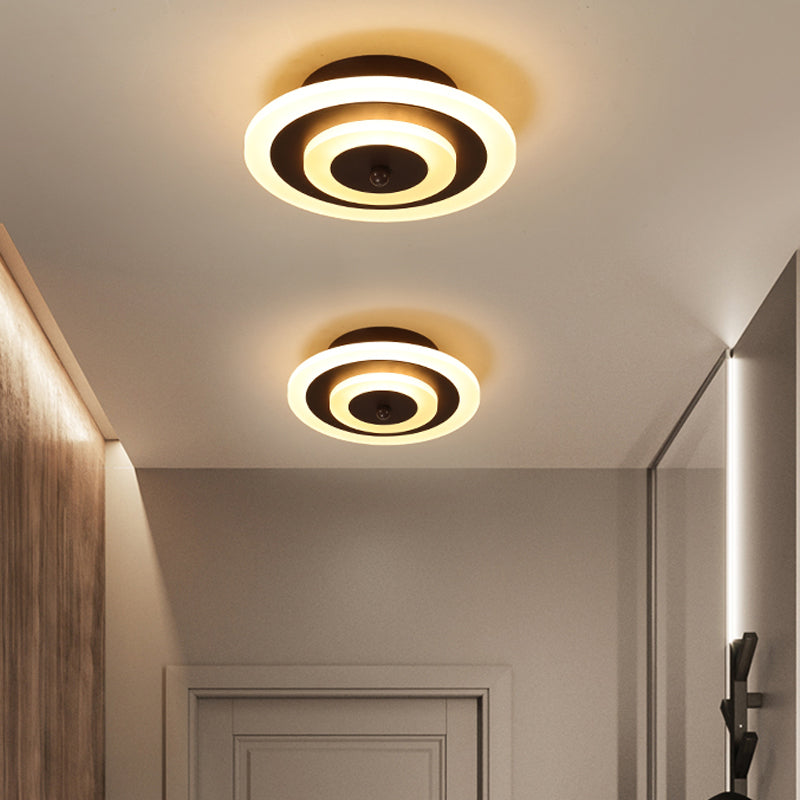 Two round coffee ceiling lights lit warm beside a hallway door