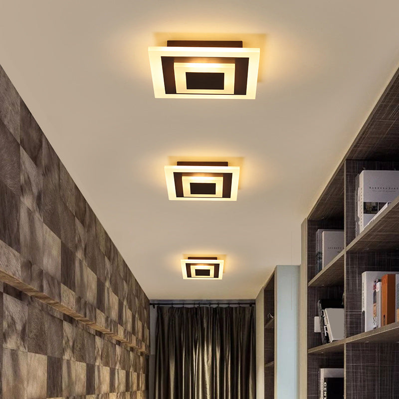 Three square coffee ceiling lights over a stone tiled corridor