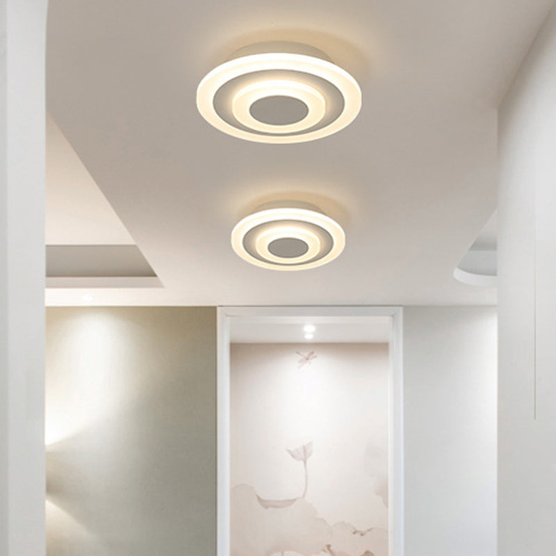 Two round white ceiling lights on a bright hallway ceiling