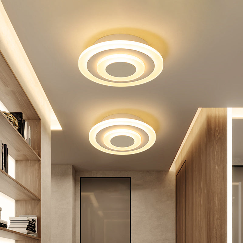 Two round ceiling lights in a corridor with recessed shelving