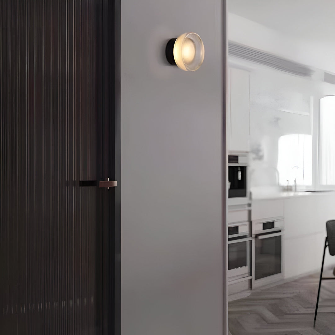 Gold ribbed wall light on a plain white wall at an angle