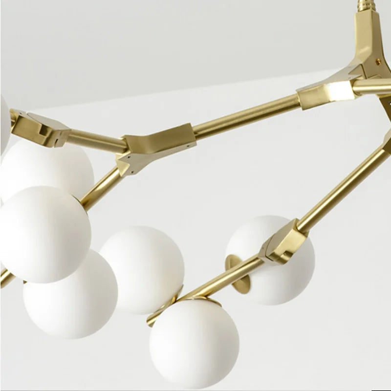 Close view of the gold branch arms holding frosted glass globes