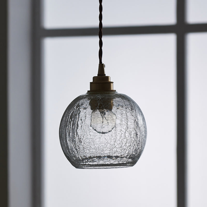 Squat crackle glass pendant in cool daylight beside a window frame