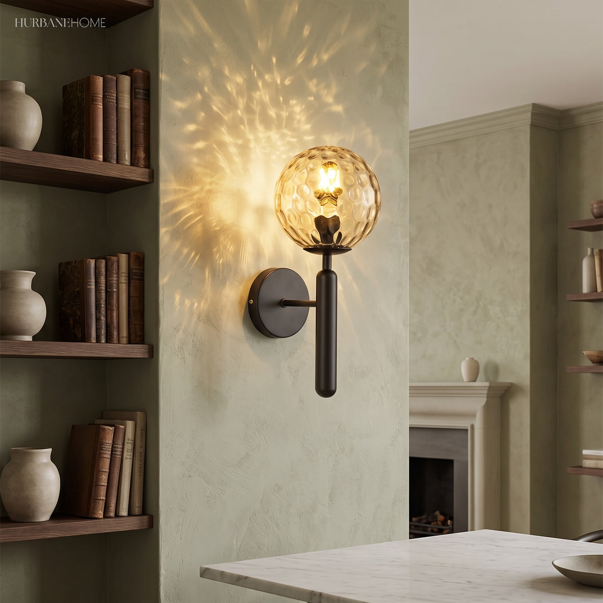 Black sconce with a ripple glass globe on a green wall by shelving