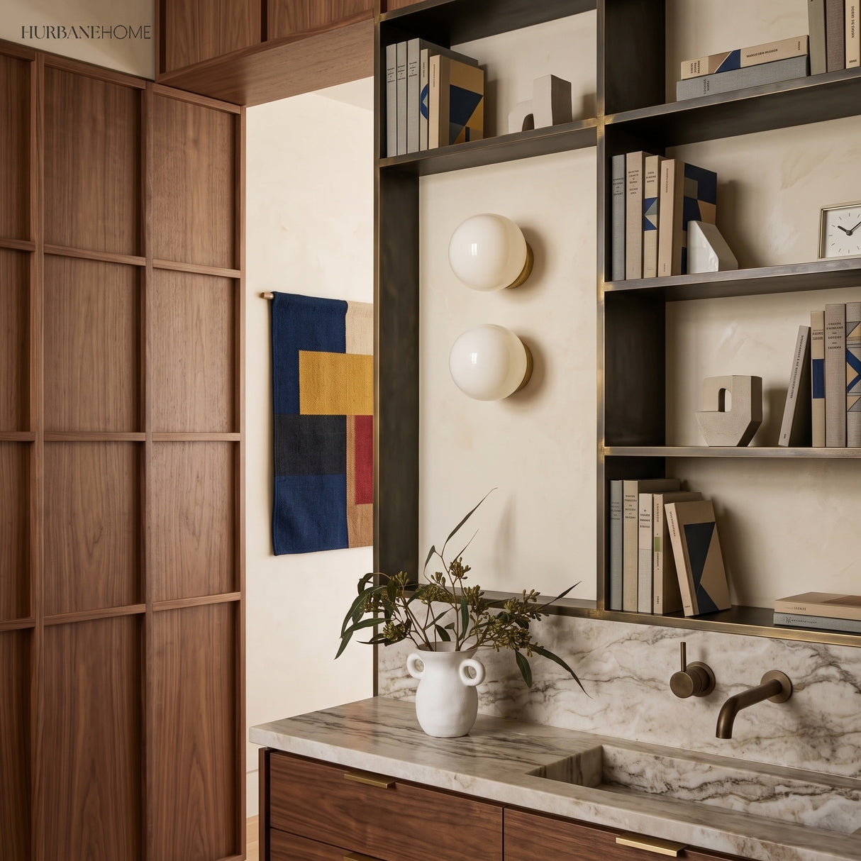 Pair of glass wall sconces on a cream study wall with marble counter