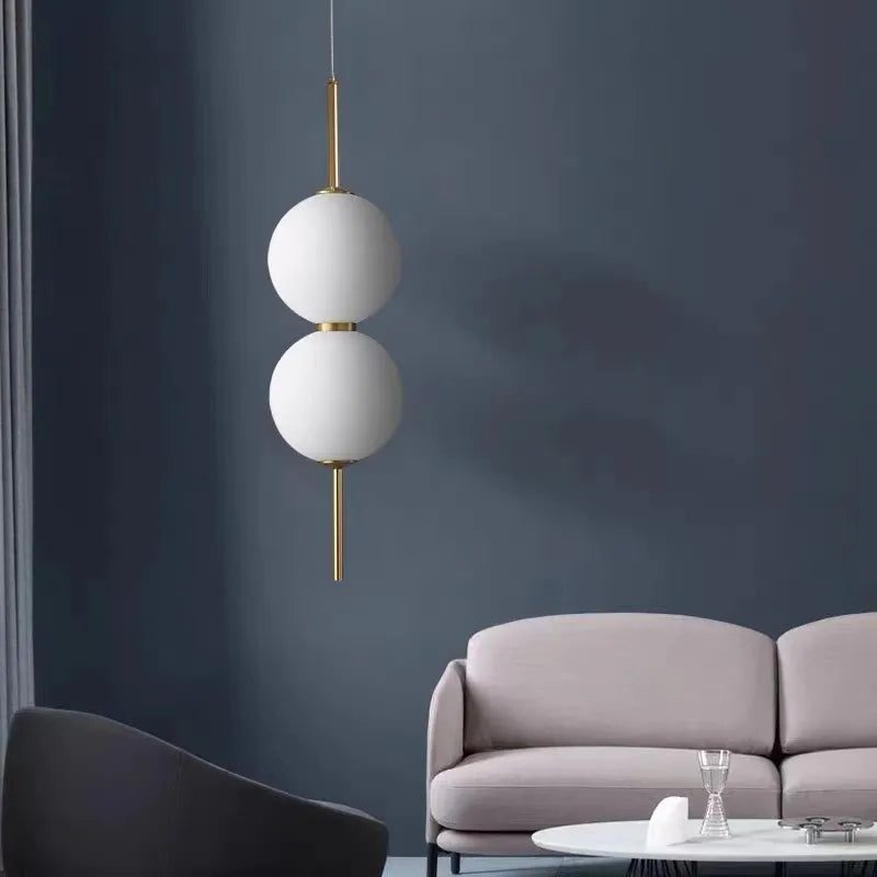 Two opal globes on a brass rod against a dark blue wall