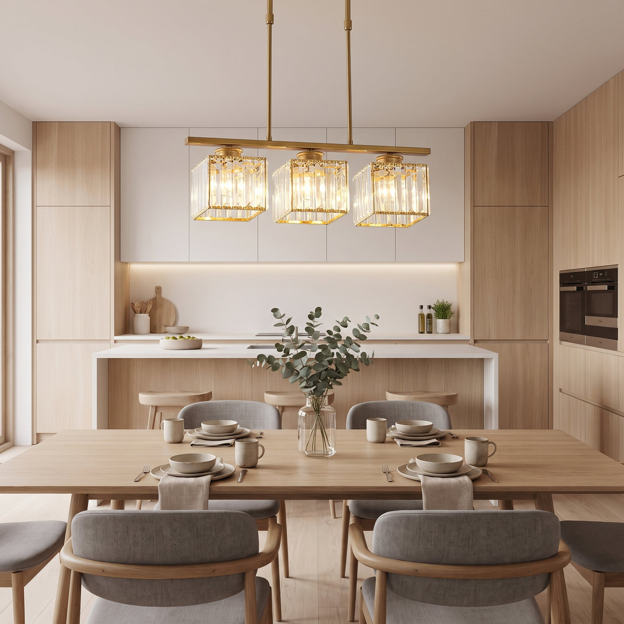 Gold kitchen island pendant light with three shades over a set dining table