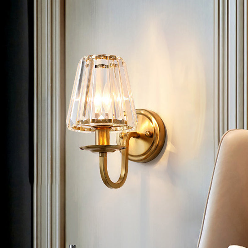 Gold sconce casting warm light across a panelled interior wall