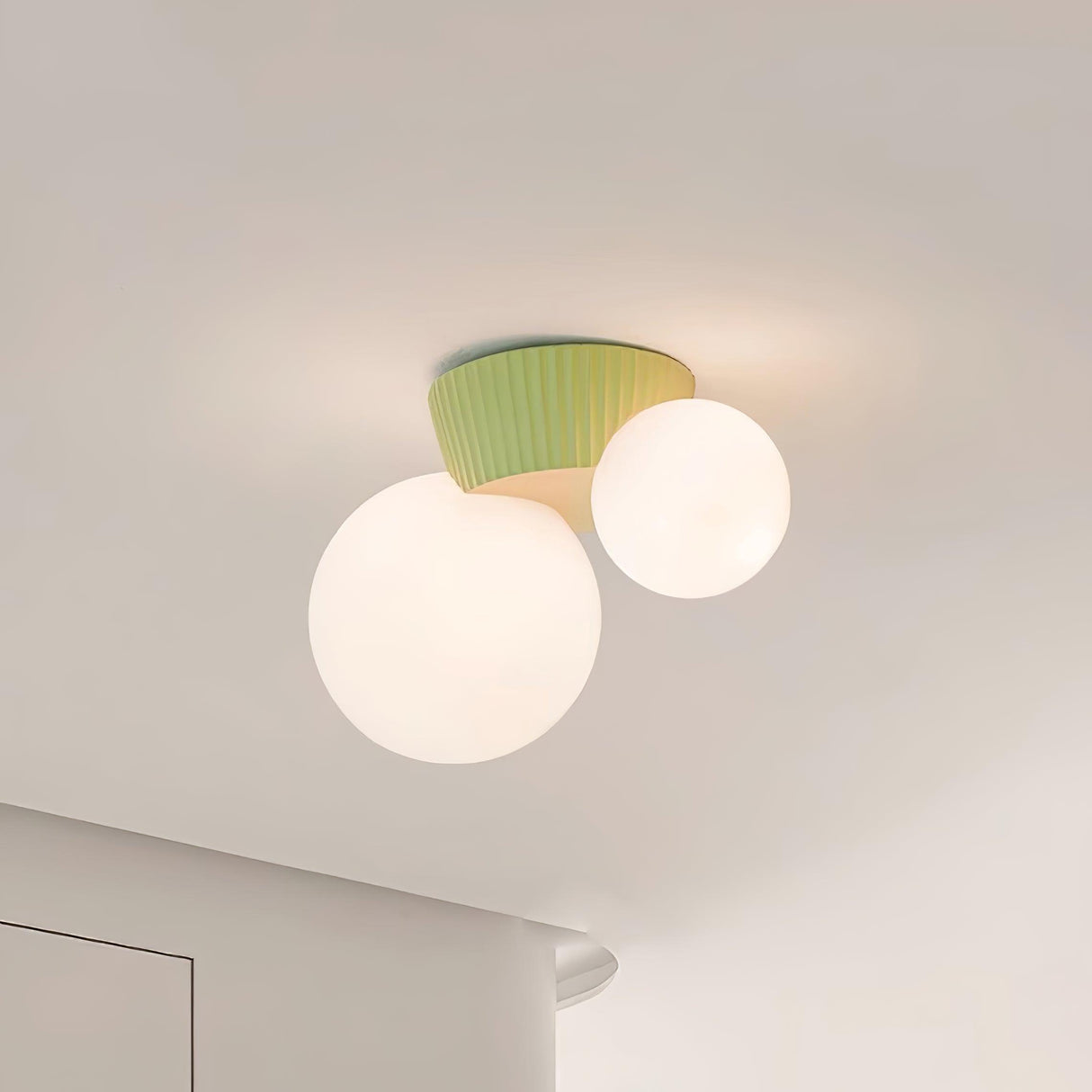 Close view of the green fluted canopy above the two lit opal glass globes