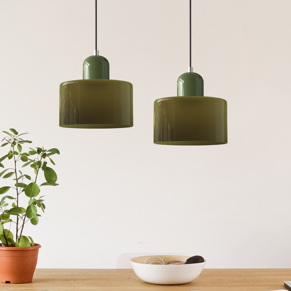 Two green glass pendant lights above a kitchen counter with a potted plant