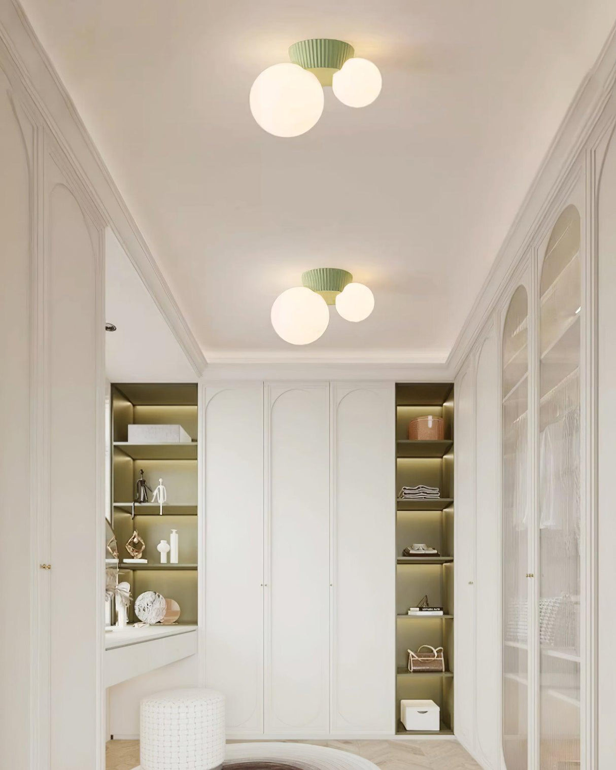 Green canopy globe light in an arched hallway lined with glazed cabinets