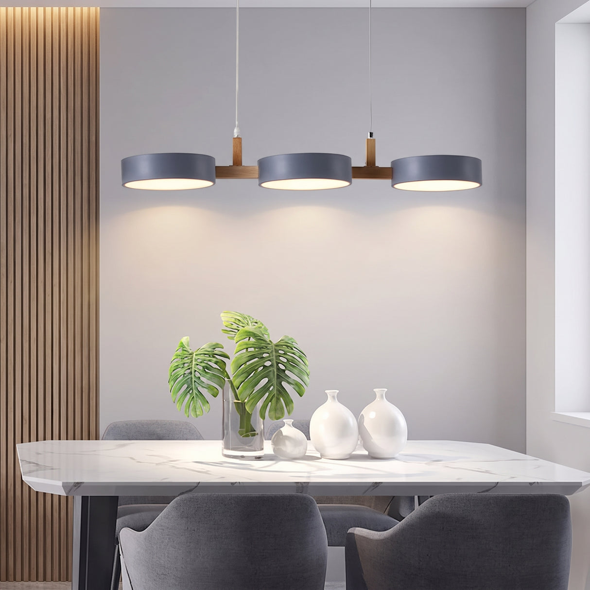 Three matching grey drum shades casting warm pools onto a marble dining table