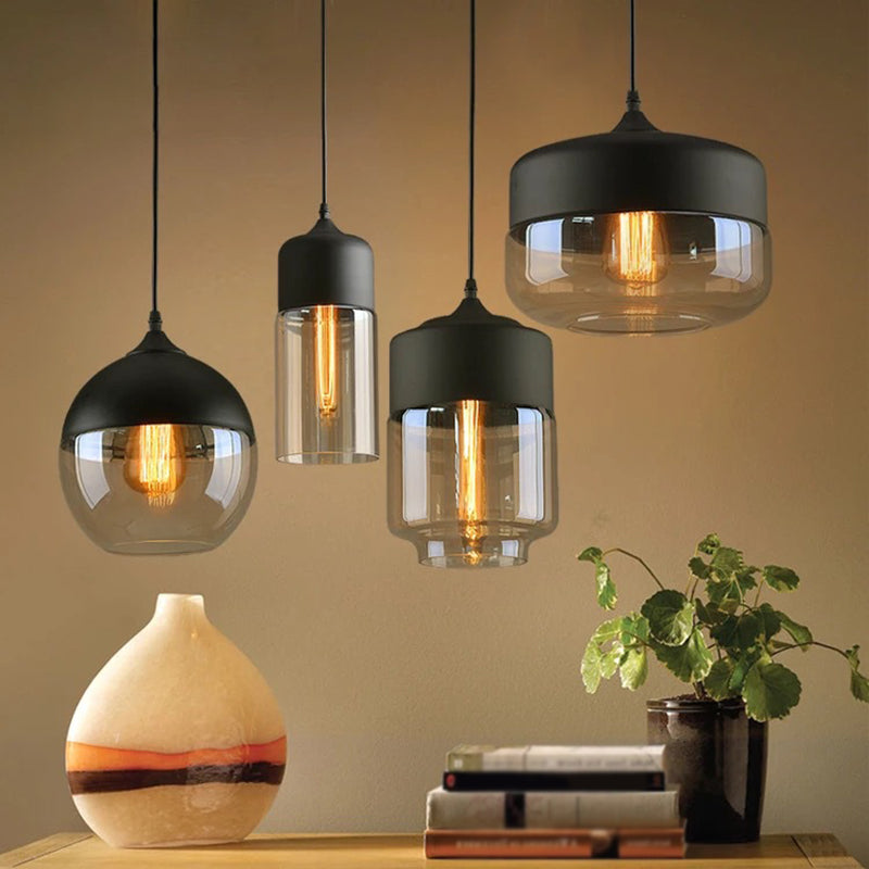 Four glass pendants lit warm above a sideboard and a plant