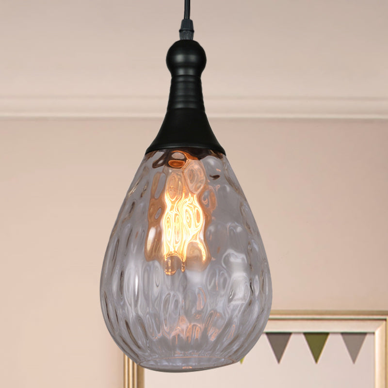 Clear dimpled teardrop pendant lit in a pale room with bunting