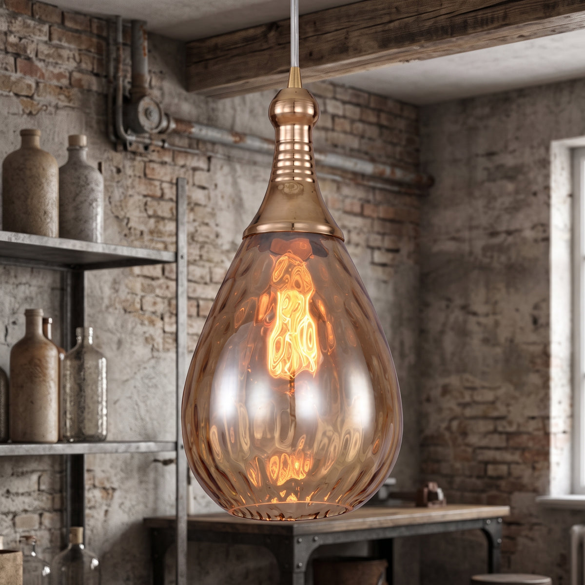 Teardrop glass pendant lit above a rustic workbench in a brick room