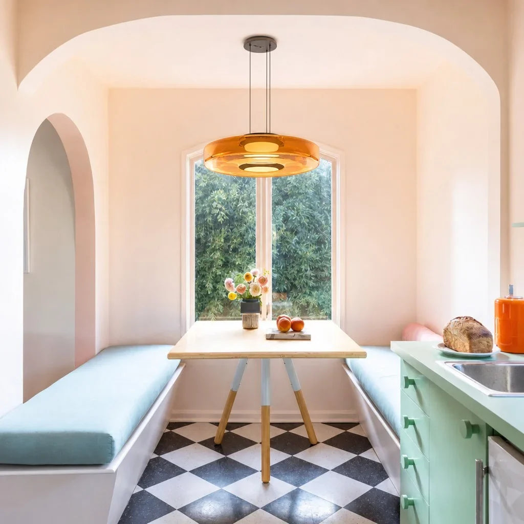 Amber glass pendant light over a pink breakfast nook with checkerboard floor