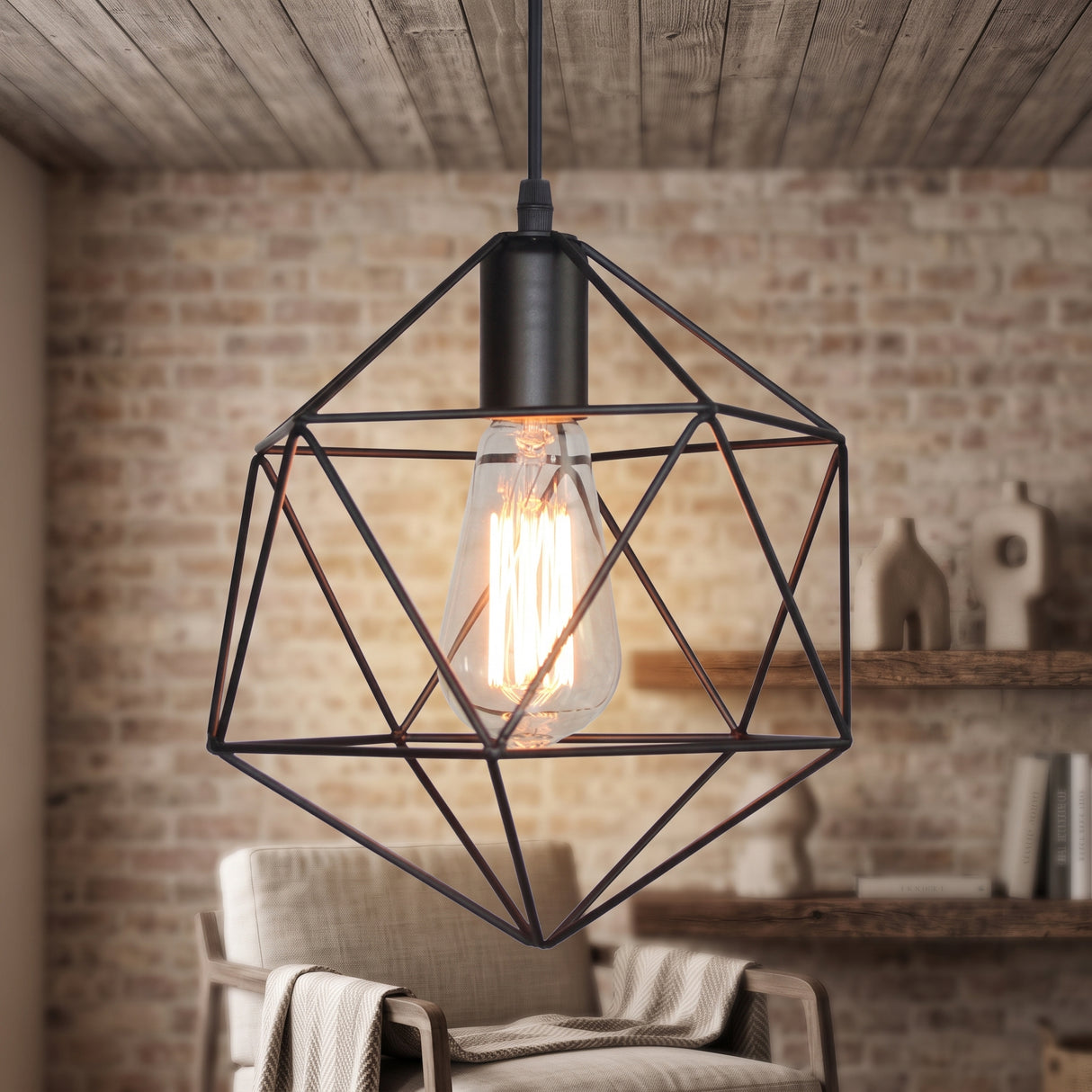 Black cage pendant with a filament bulb against an exposed brick wall