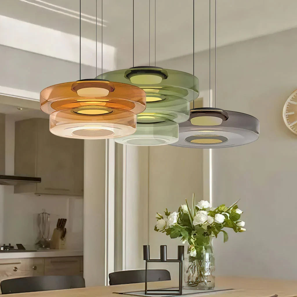 Cluster of amber green and smoke glass pendant lights over a kitchen island
