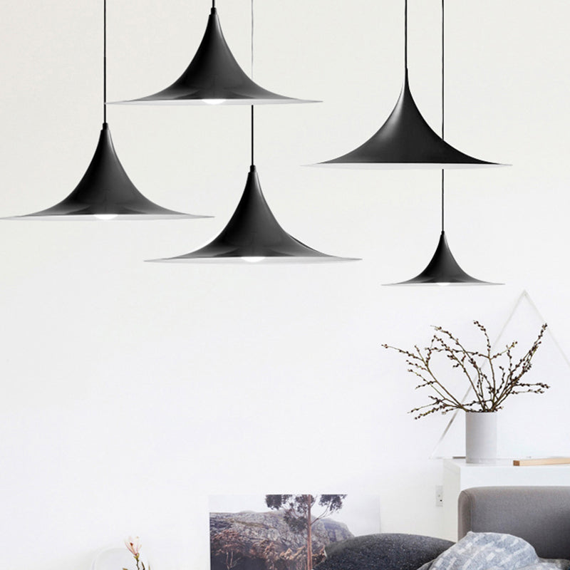 Three black flared pendants staggered above a white living room