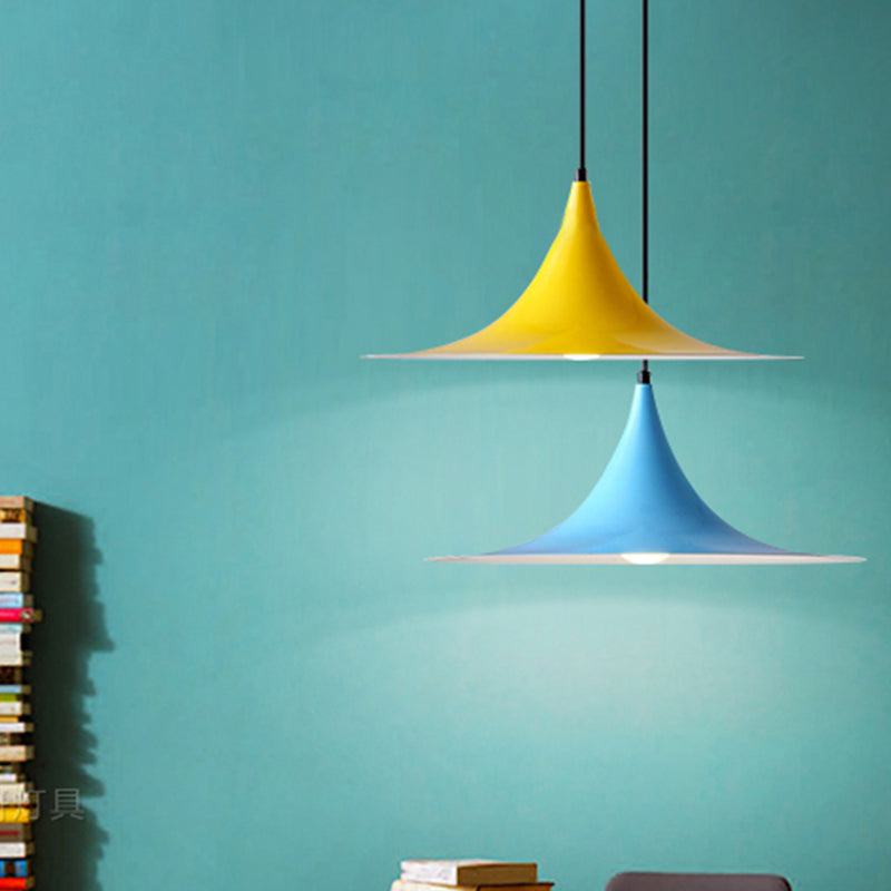 Yellow and blue flared pendants against a bright teal painted wall