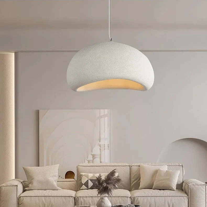 White dome pendant lit above a console table and framed art