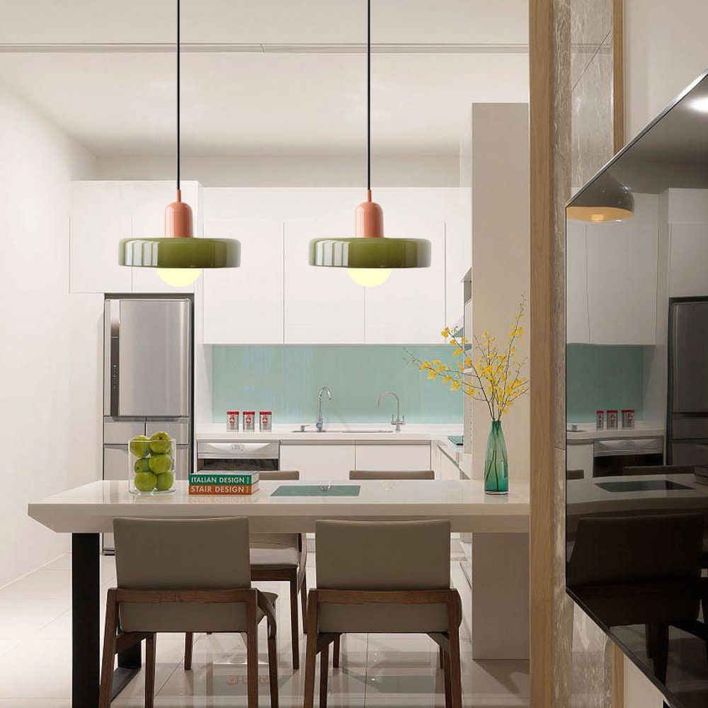 Pair of olive glass pendant lights above a white kitchen breakfast bar