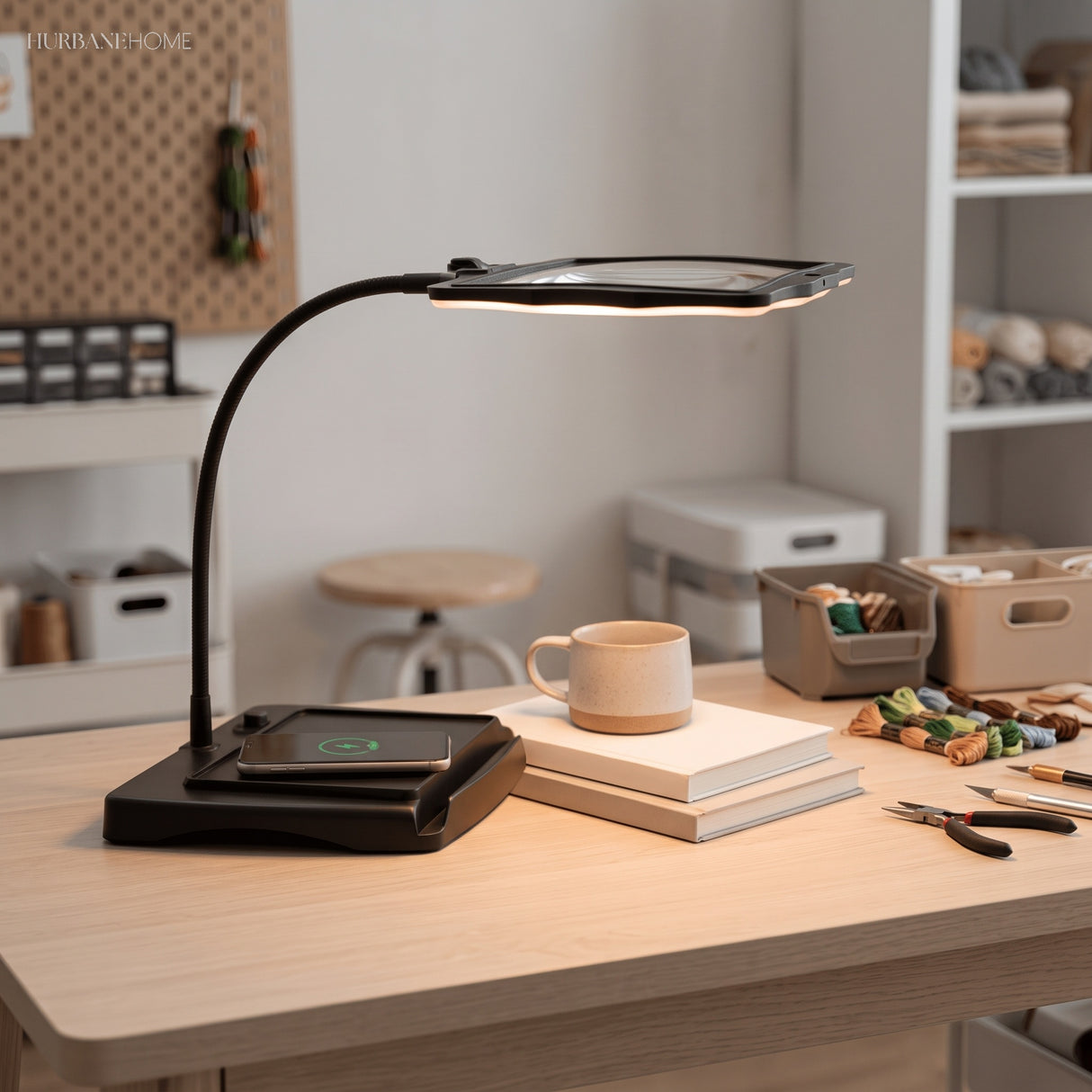 Black LED magnifier lamp lit warm in a tidy embroidery craft room