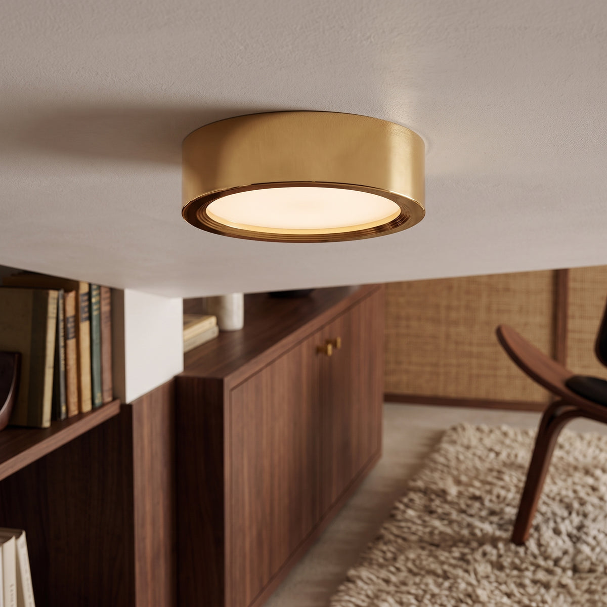 Gold surface mount ceiling light above a timber bookshelf and chair
