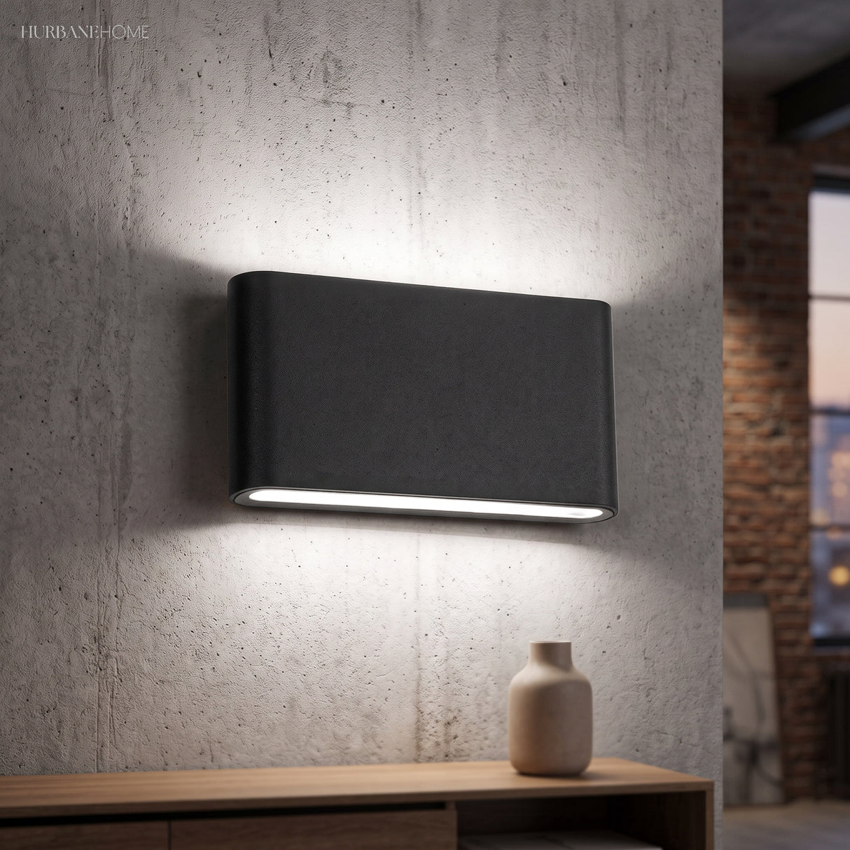 Black rectangular sconce casting up and down beams on a concrete wall