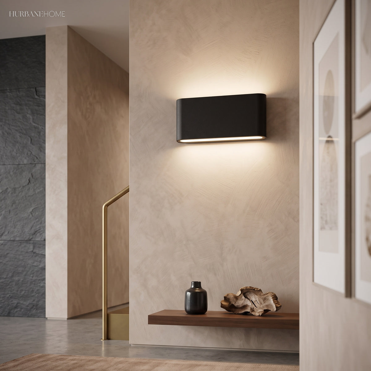 Black aluminum wall sconce washing light up a beige hallway wall