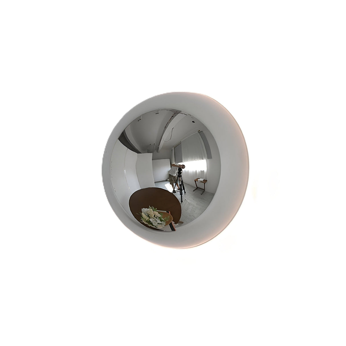 Silver mirrored dome sconce seen at an angle on a white ground