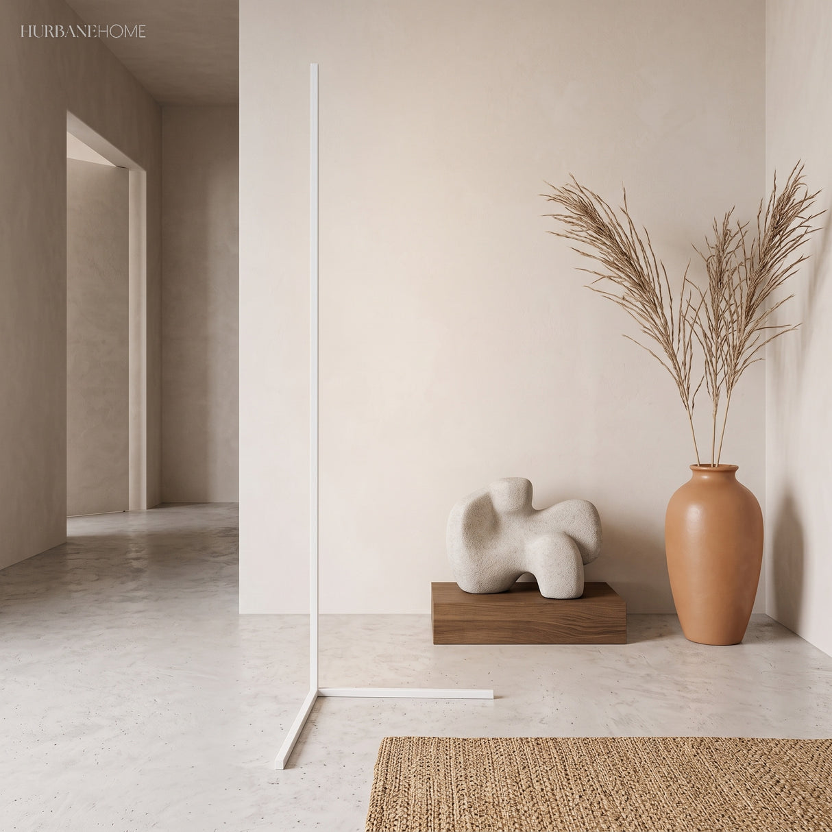 White corner floor lamp with warm glow next to a terracotta vase and sculpture