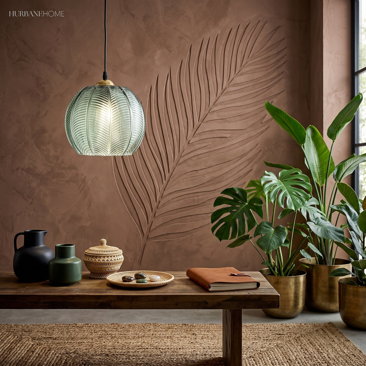 Green textured glass pendant over a timber console with dark vases and leafy houseplants