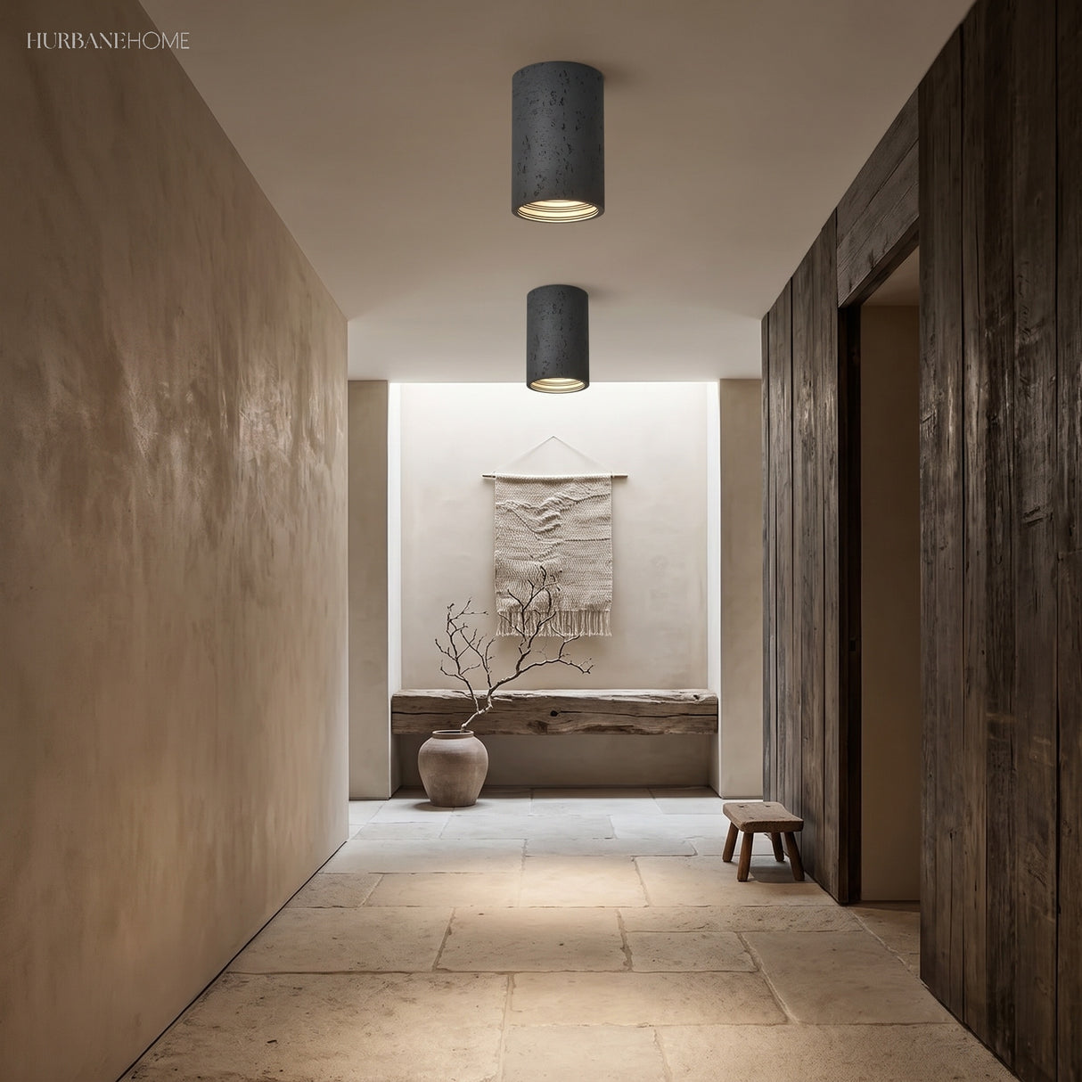 Two black composite surface-mount ceiling lights over a stone-floored hallway
