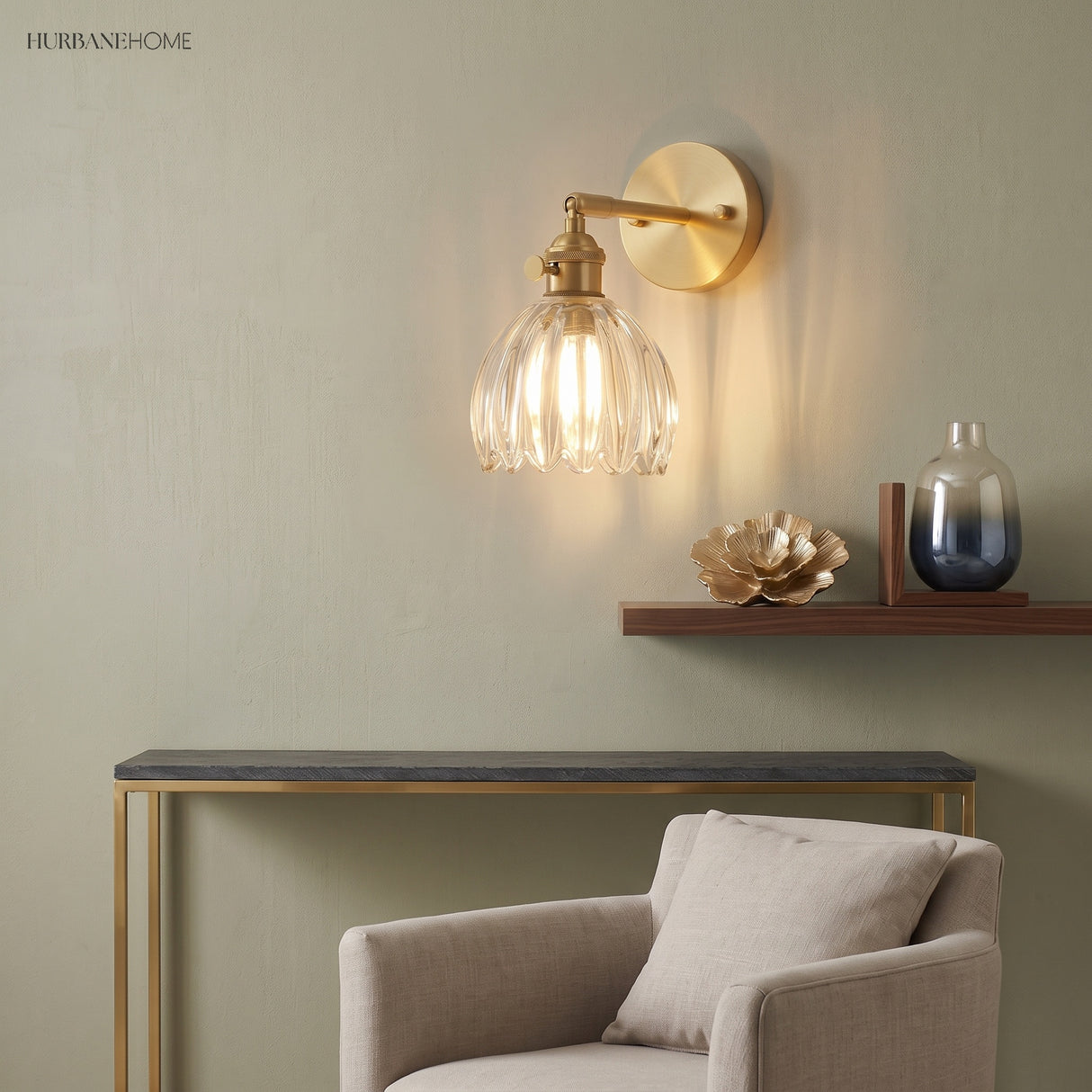 Clear scalloped glass sconce above a slim console and pale armchair