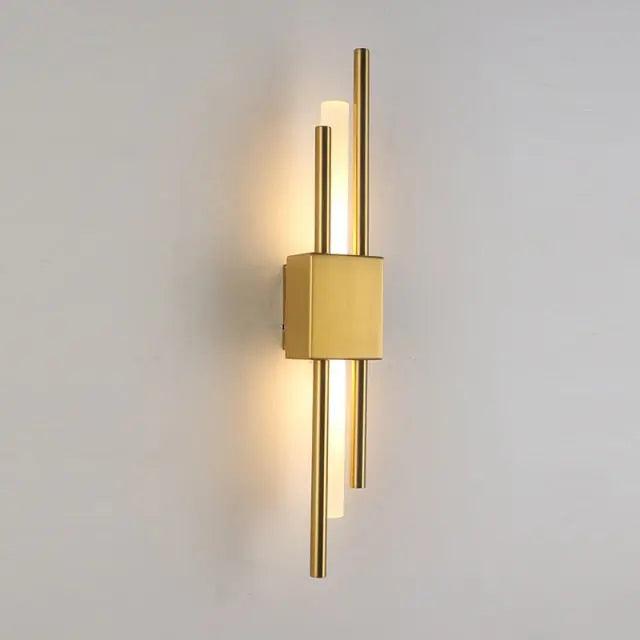 Brushed gold twin bar sconce lit against a plain grey background