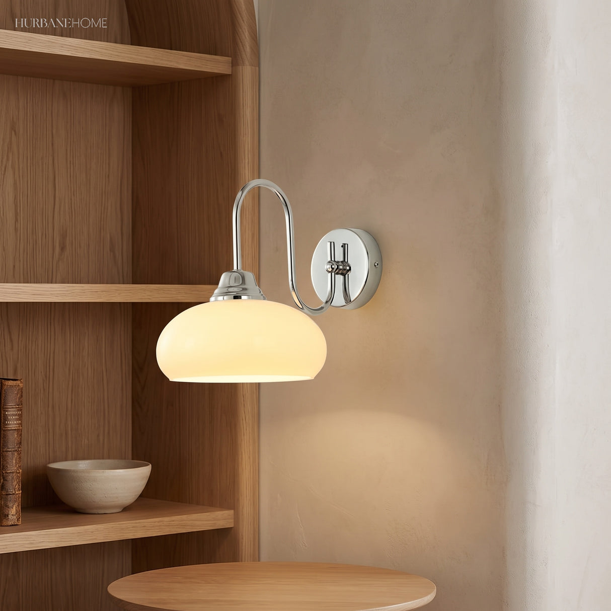 Chrome bracket milk glass wall sconce mounted near oak shelving
