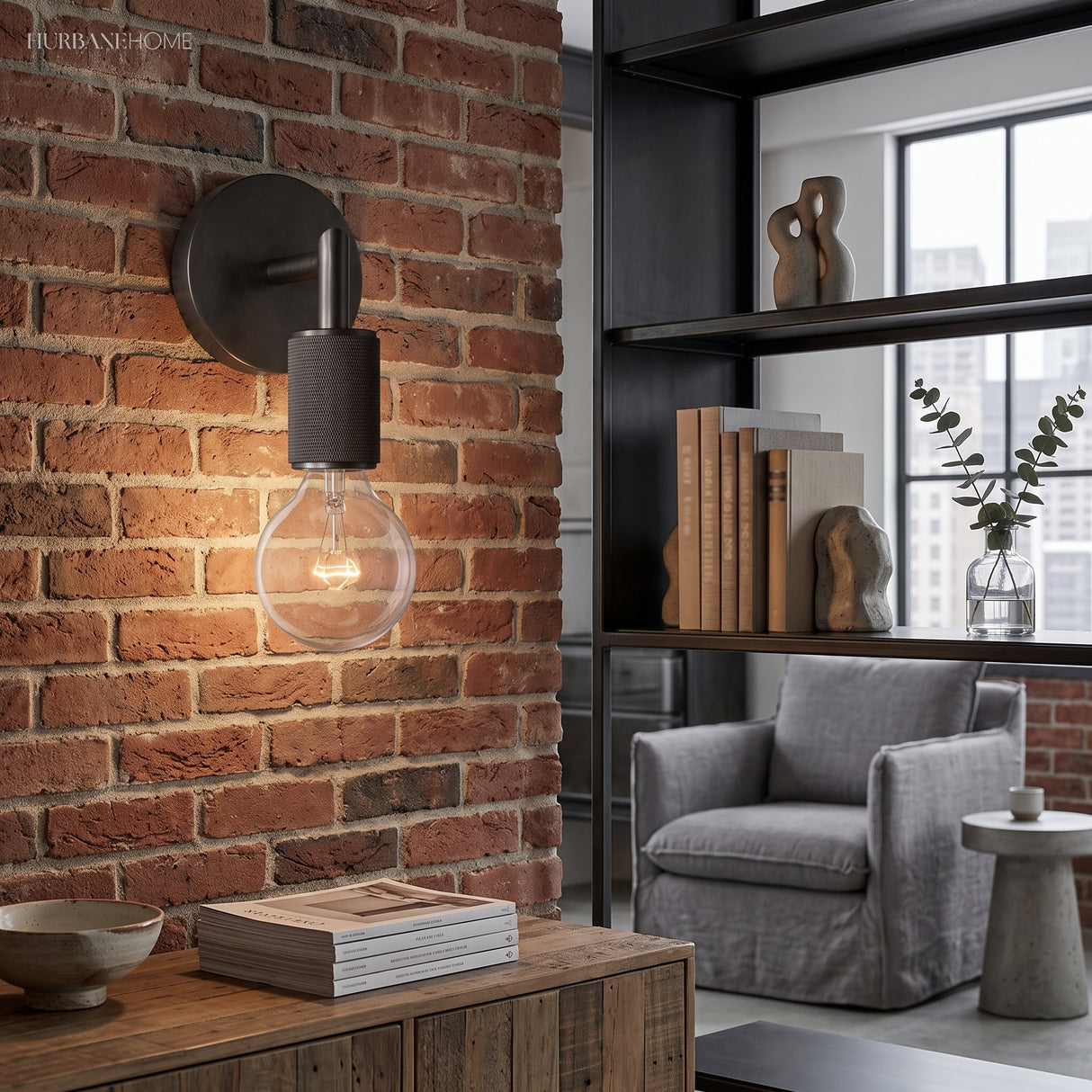 Black bare bulb sconce mounted on exposed brick in a loft room