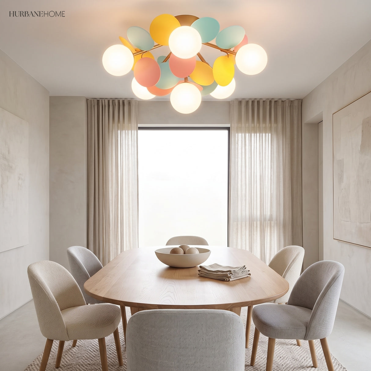 Cluster ceiling light with pastel discs lit above a pale oval dining table