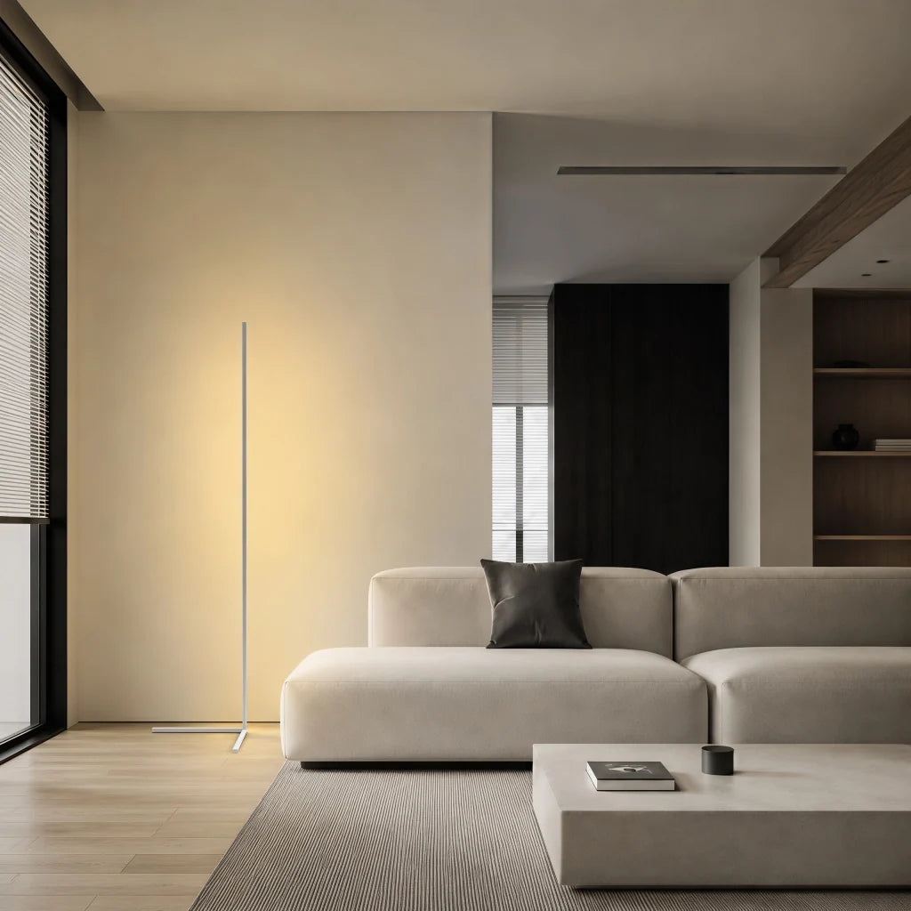 White floor lamp casting warm light near a beige sofa and jute rug