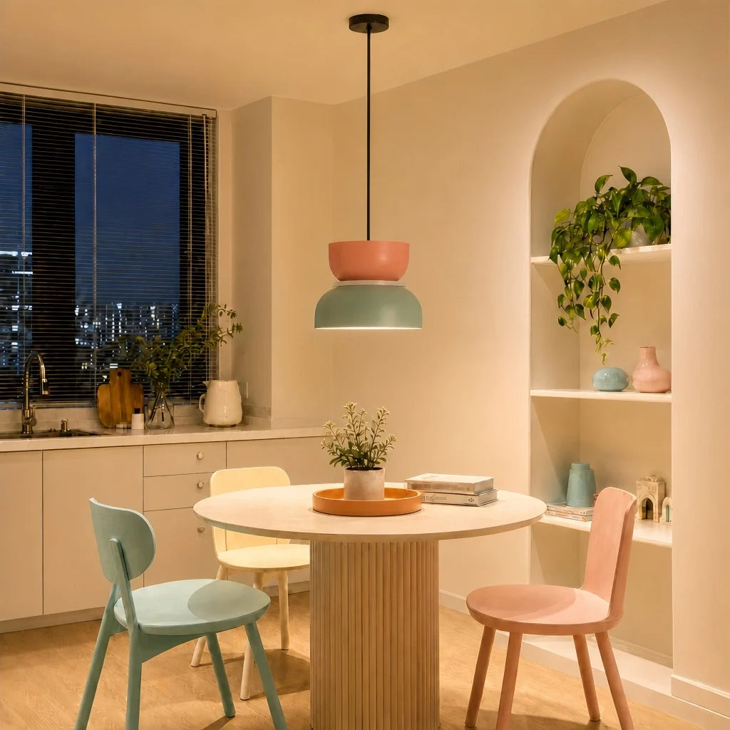 Pink and light green pendant lit in a beige kitchen-diner at night