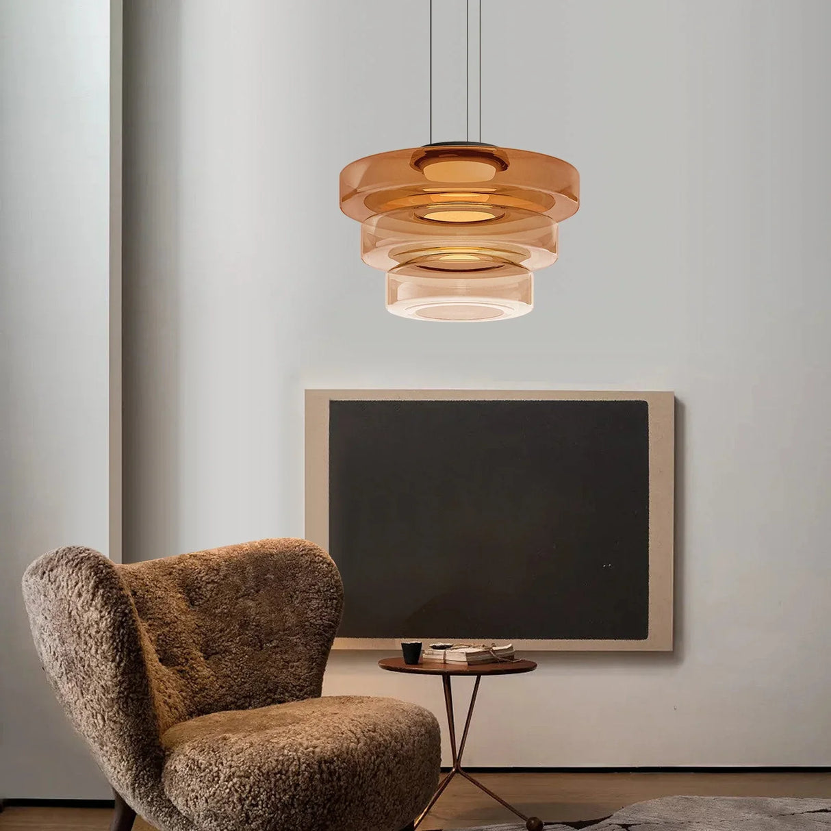 Amber three-layer glass pendant light in a grey living room with a sheepskin chair