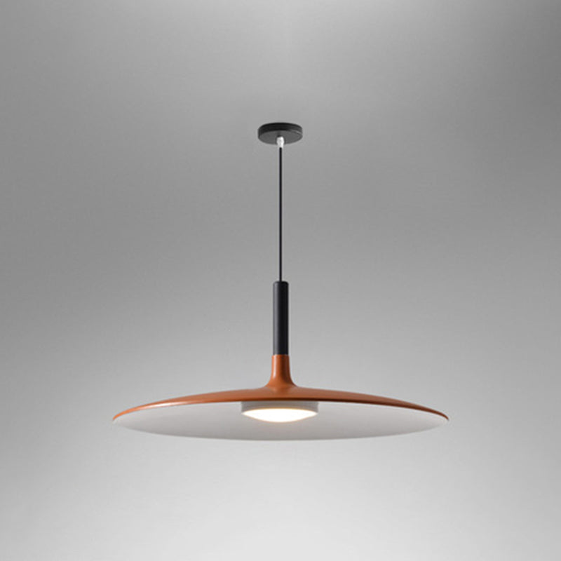 Orange saucer pendant shade shown lit on a grey background