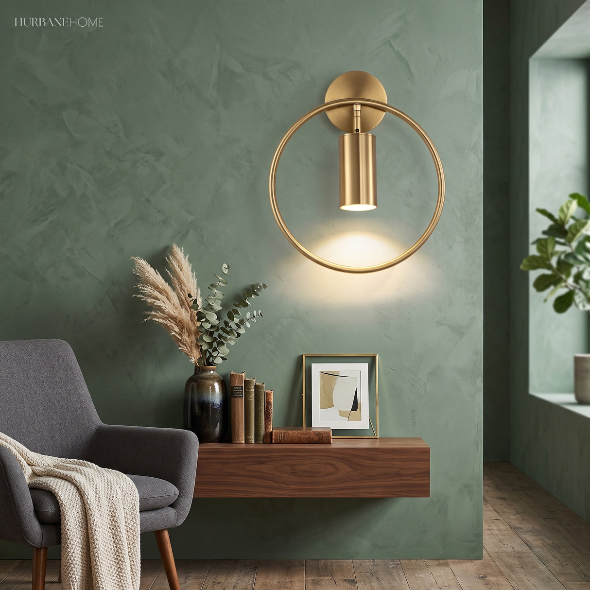 Gold hoop sconce lit above a console table against a green wall
