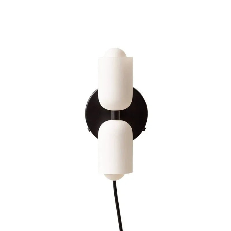 Two white cylinders on a black backplate with a trailing cord