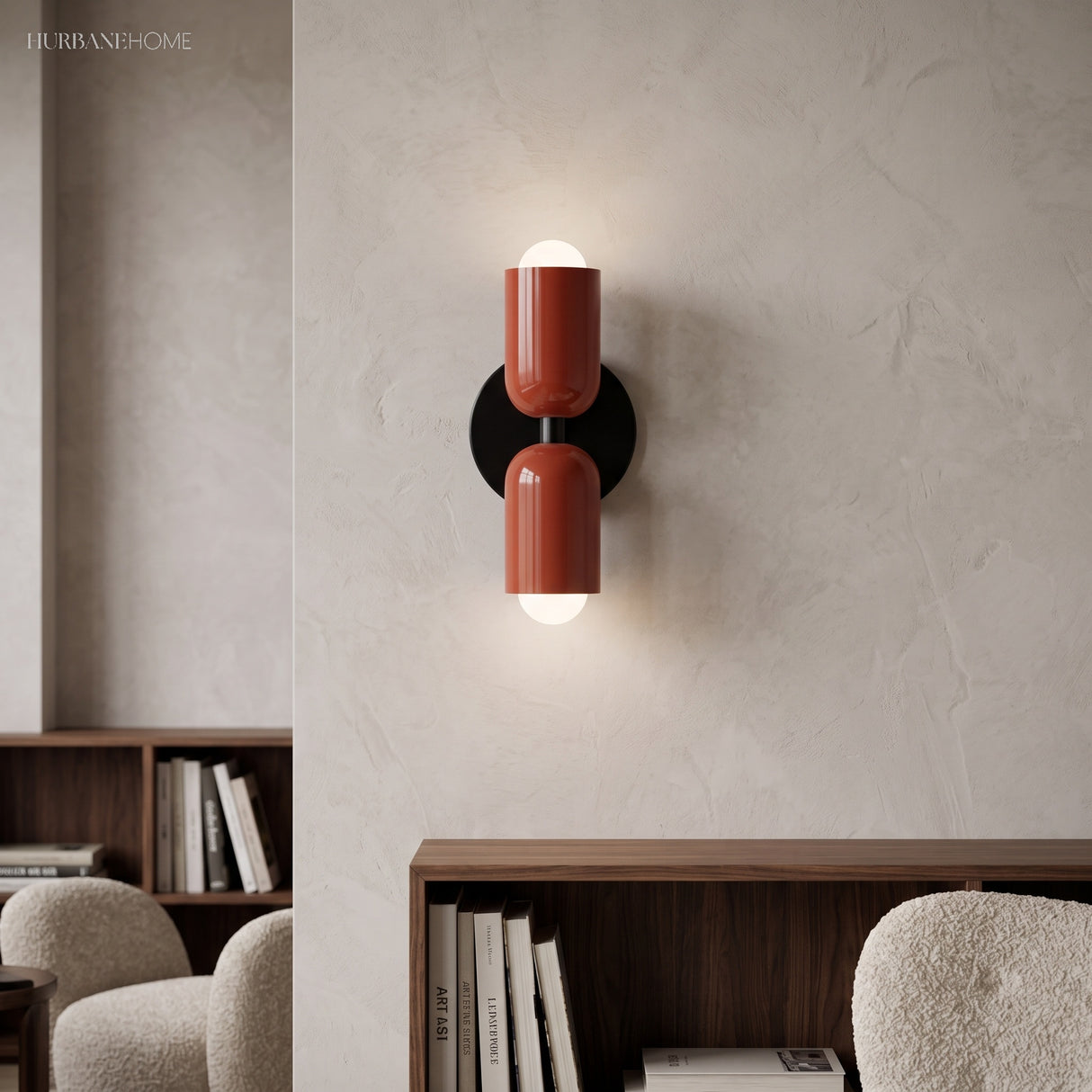 Terracotta cylinder sconce lit on a pale wall above a bookshelf