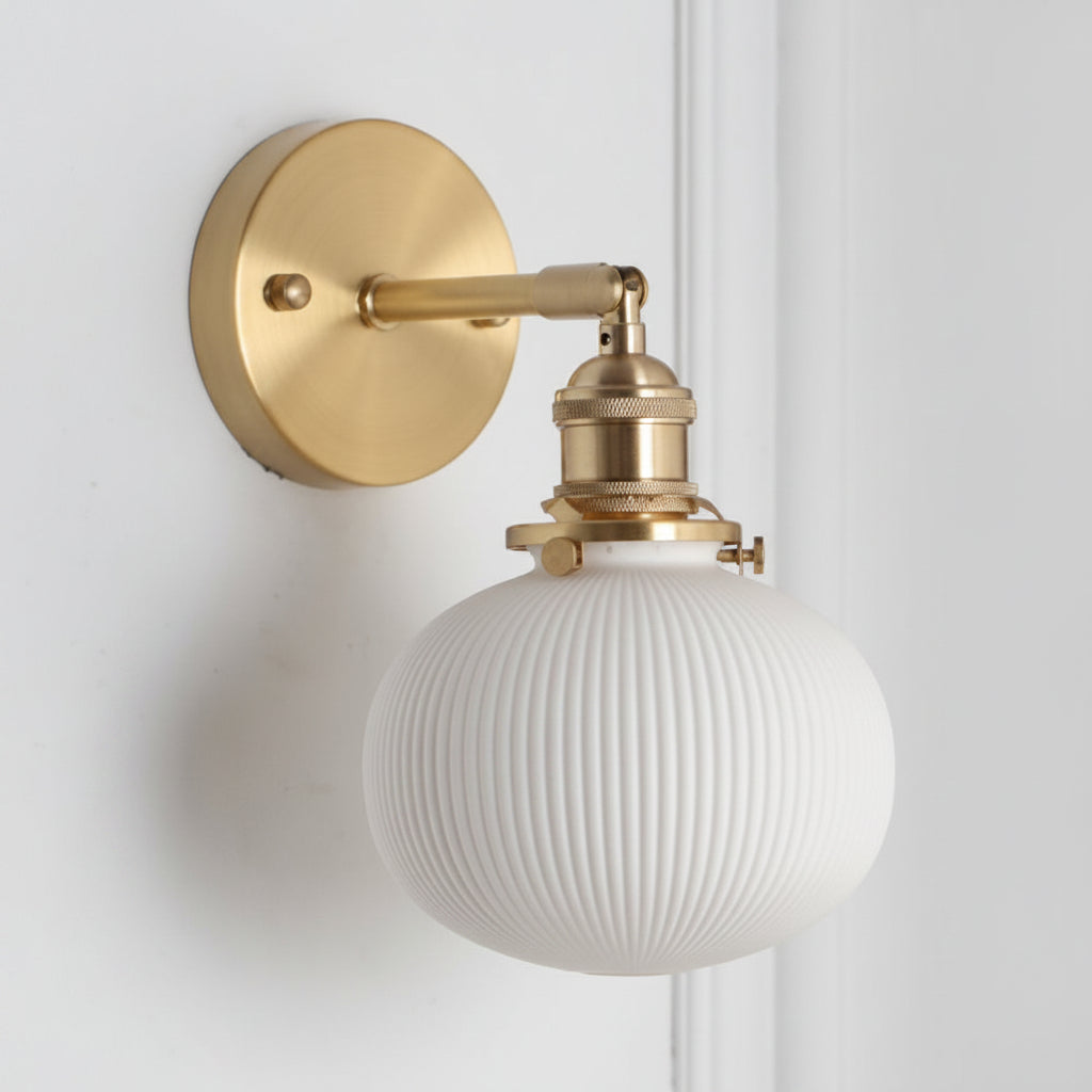 Wide ribbed white shade on a brass arm seen from the side