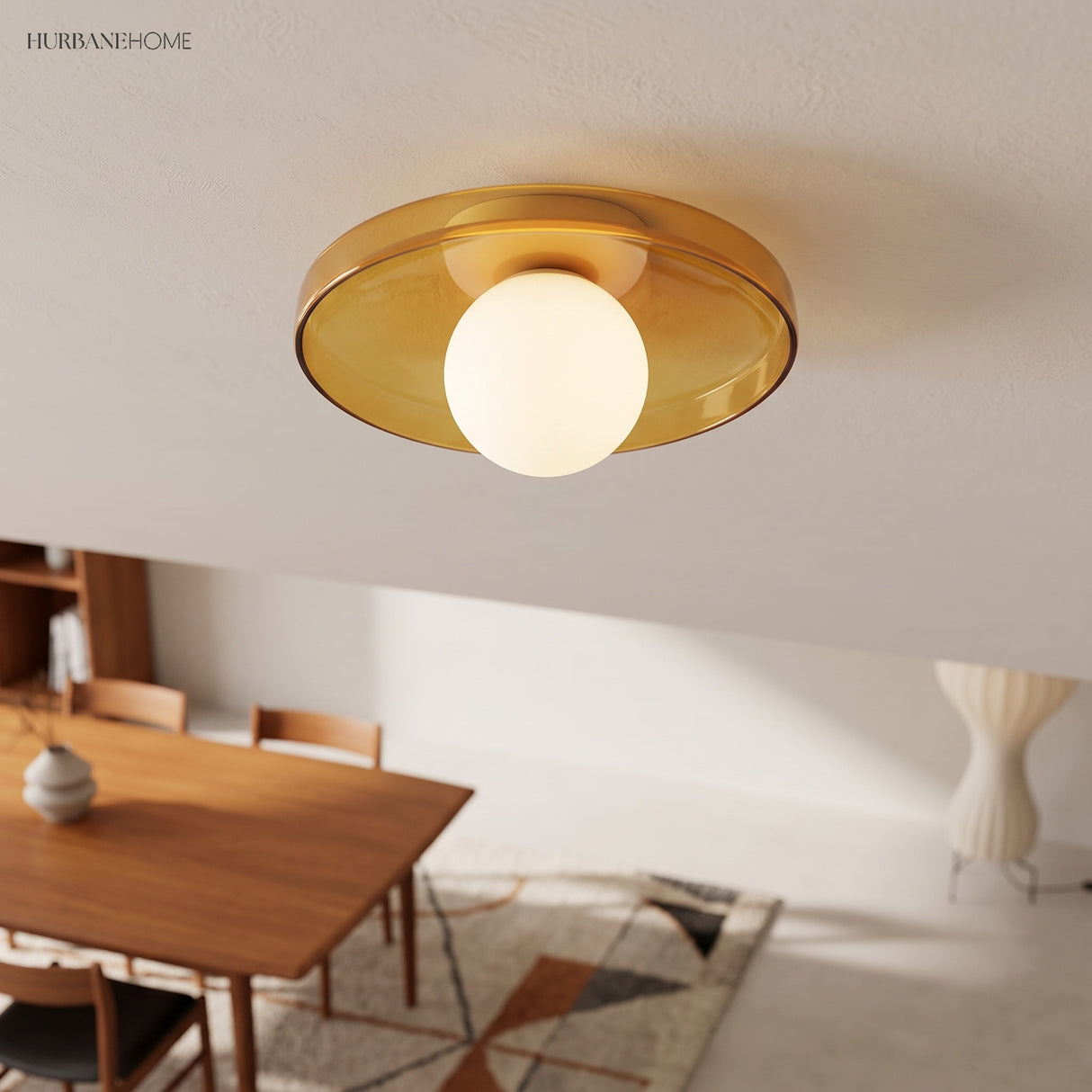 Olive disc ceiling light above a dining area