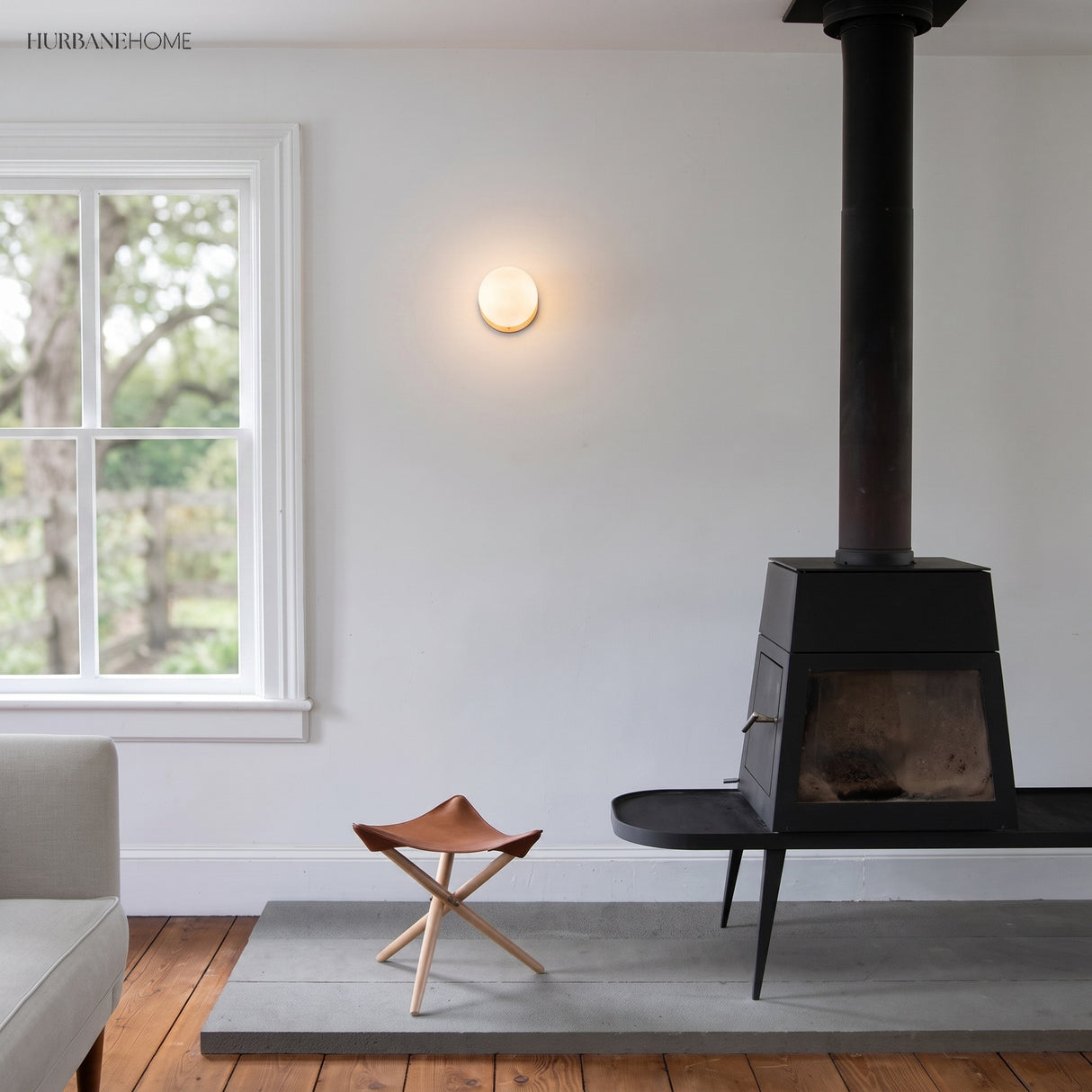 Glass globe wall lamp in a living room beside a wood burning stove